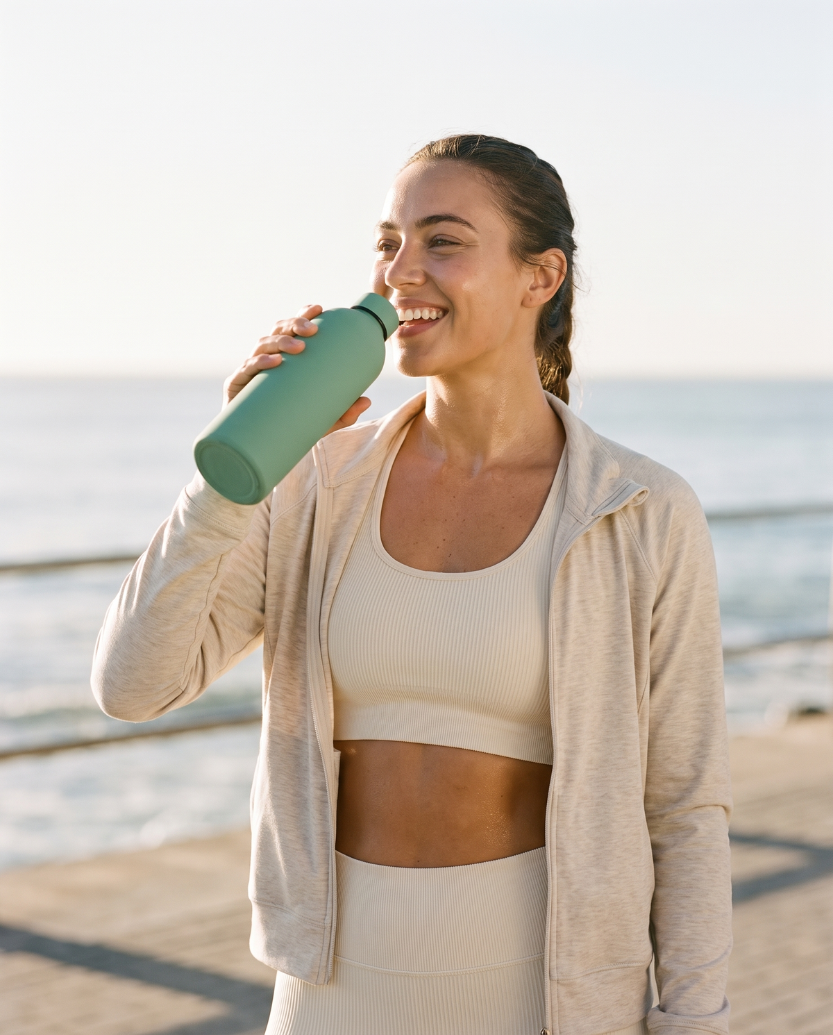 Woman drinking from the WELLURIA insulated bottle after a run